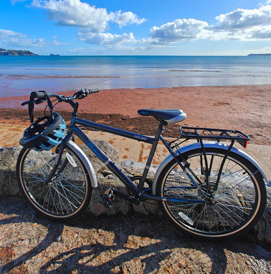 Bicycle with a helmet on a stone wall by the beach