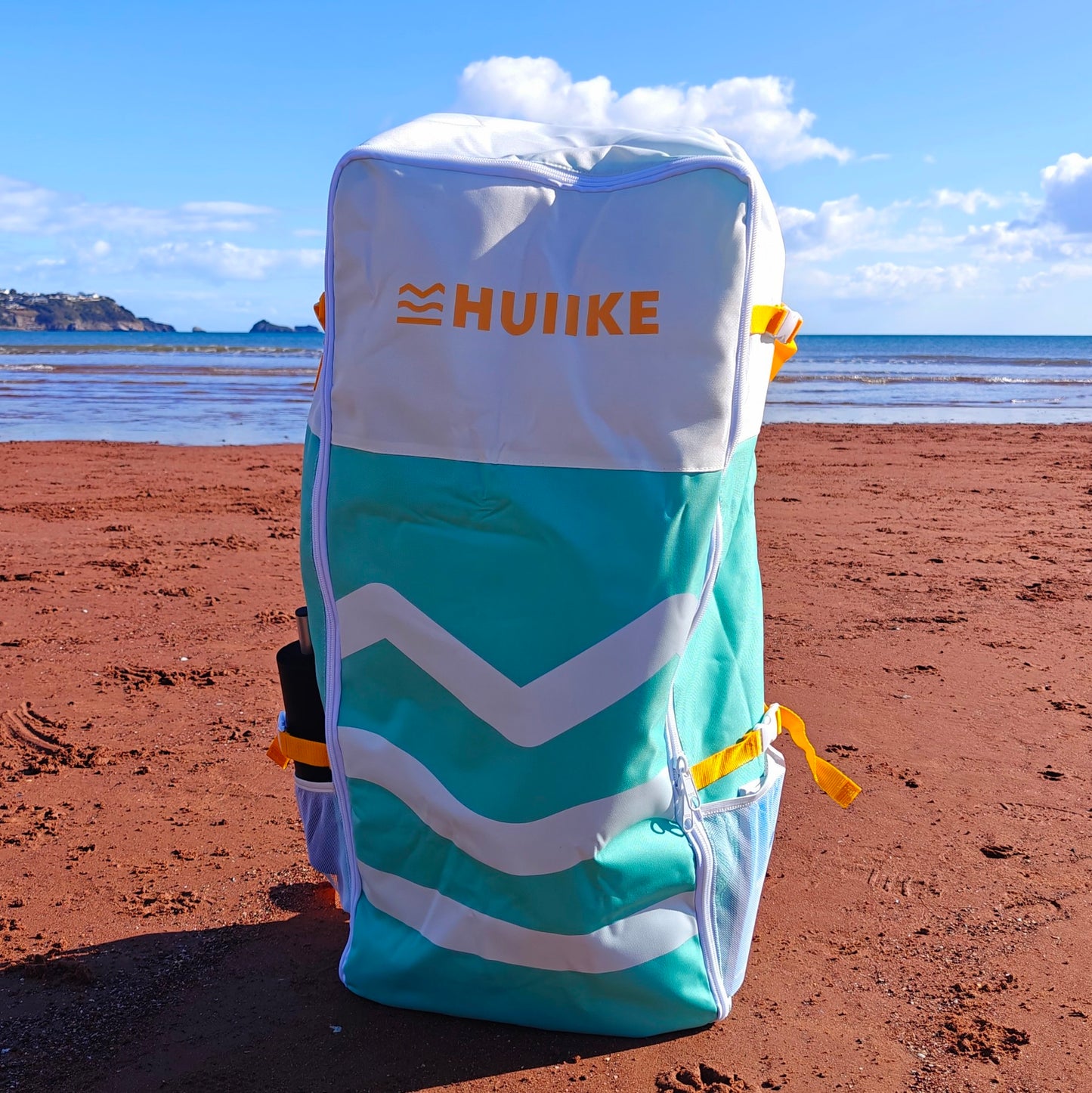 Blue and white bag with HUIIKE branding on a beach