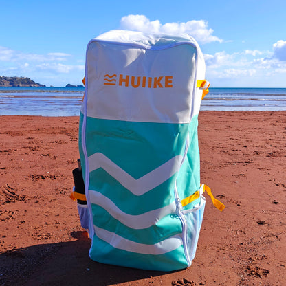 Blue and white bag with HUIIKE branding on a beach